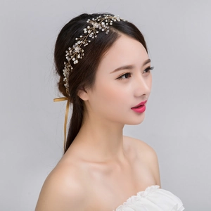 Détail d'un bandeau de mariée doré fait main avec perles blanches et cristaux