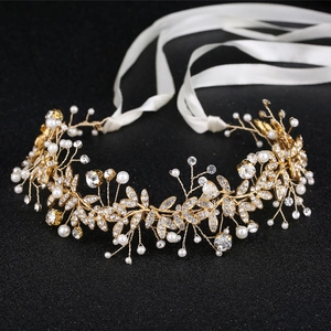 Elegante copricapo da sposa con foglie in lega, perle e cristalli su uno sfondo nero scuro