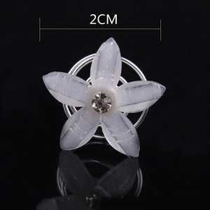 Detail view of 2cm bridal hair screw with white resin flower and sparkling rhinestone center