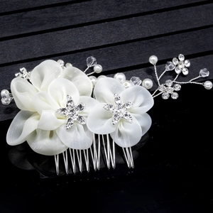 Détail de fleurs en mousseline blanche avec étoiles en cristal et perles sur peigne mariée