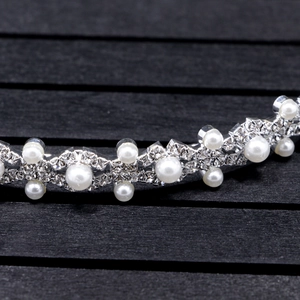 Vue macro du serre-tête de mariée en argent avec strass brillants et perles blanches