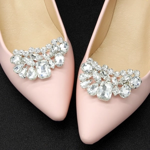 Detailed close-up of pink pointed-toe shoes with large symmetrical crystal rhinestone buckles