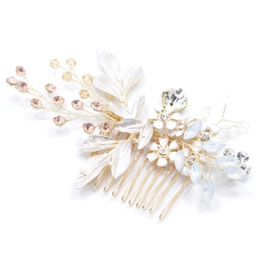 Detail of gold bridal hair comb with white leaves, peach beads and sparkling rhinestones