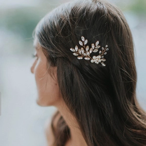 U-shaped bridal hair pin with pearls and leaf-shaped crystals on an elegant model