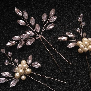 Detail of three silver bridal hair pins with marquise rhinestones and ivory pearls