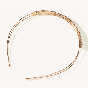 Détail d'un serre-tête double couche or rose orné de cristaux étincelants et de perles