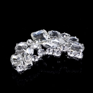 Elegant crystal bridal shoe clip featuring symmetric rhinestone design on black background