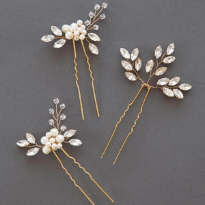 Close-up of handmade bridal U-shaped hair pins with gold wire, pearls and marquise rhinestones