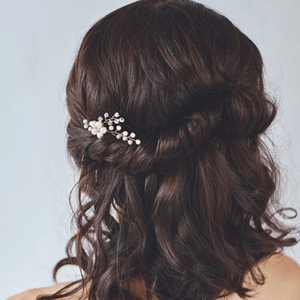 Détail d'une épingle à cheveux de mariée avec perles et cristaux sur cheveux bruns