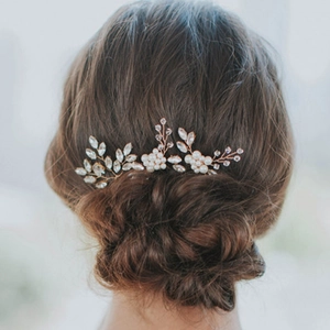 Elegant rose gold bridal hair comb with pearls and crystals on a low bun hairstyle