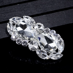 Macro shot of silver bridal shoe clip with pear-cut crystals and marquise diamonds