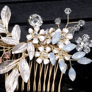 Macro detail of bridal hair comb with gold wire, white enamel flowers and rhinestones
