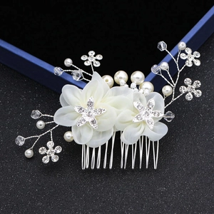 Détail d'un peigne de mariée avec fleurs en mousseline, strass et perles d'imitation