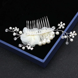Détail du peigne de mariée en fil d'argent avec fleurs en mousseline, perles et cristal