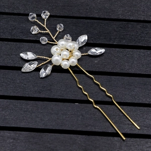 Détail d'une épingle à cheveux de mariée avec perles et strass sur fil métallique doré