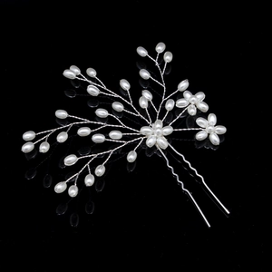 Detail of bridal hair pin with handmade white pearls and silver wire floral design