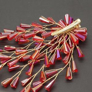 Elegant bridal hair clip with red crystal beads and gold wire tassels on black background