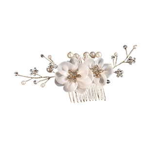 Détail de peigne à cheveux de mariée avec fleurs en mousseline et cristaux blancs