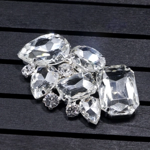 Macro detail of symmetric crystal bridal shoe clips with multi-cut rhinestones and silver base