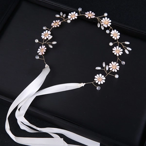 Close-up of handmade bridal headband with white daisy flowers and silk ribbons