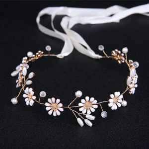 Detail of bridal headband with gold wires, white daisies, pearls, and ribbons