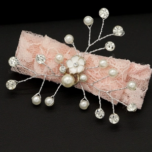 Dettaglio del fermaglio per capelli in pizzo rosa con perle, strass e fiore in smalto