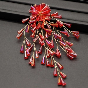 Macro shot of red crystal bead tassels and golden wire weaving for bridal hair accessory