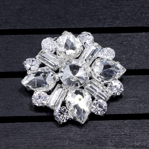 Close-up of a sparkling crystal flower shoe clip with a large round center stone