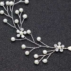 Dettaglio di fascia per capelli da sposa con filo d'argento, perle e fiori di cristallo