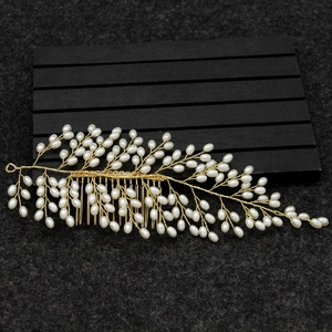 Detailed macro view of handmade gold wire bridal hair comb with elegant white pearls