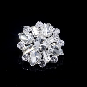 Macro detail of bridal shoe clip with symmetric crystal flower and silver metal base