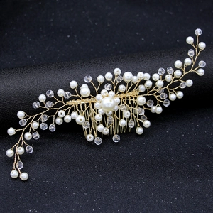 Elegant gold bridal hair comb with pearls and crystals on a professional black stand