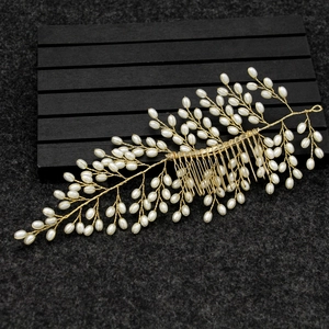 Handmade golden bridal hair comb with elegant leaf shapes and white faux pearls