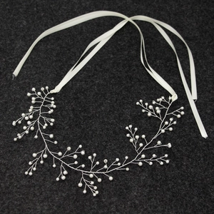 Detail von handgefertigtem Perlen-Haarschmuck mit Silberdraht und Satin-Bändern
