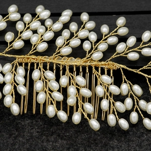 Macro shot of gold wire leaf bridal hair comb with elegant white pearls for wedding