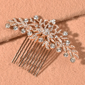 Elegant rose gold bridal hair comb with floral rhinestone design on warm camel fabric
