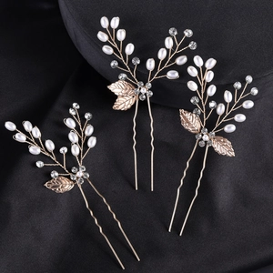 Detail of baroque gold leaf bridal hair pins with pearls and crystals set on black silk