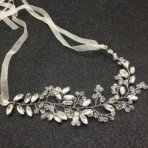 Detail of silver bridal hair vine with crystal leaves and white organza ribbons
