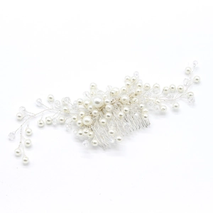Detailed close-up of handmade bridal hair comb with pearls and silver wire weaving