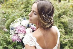 Close-up of handmade bridal hair comb with gold leaf design and delicate white pearls