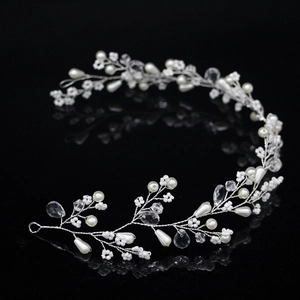 Bijou de tête mariée avec perles blanches et cristaux sur fond noir avec reflets