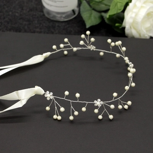 Dettaglio macro della decorazione per capelli da sposa con perle bianche e strass su nero