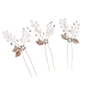 Detail of 3-piece rose gold bridal hair pins with pearls and crystal leaf accents
