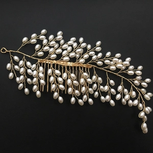 Detailed view of handmade gold wire hair comb with white pearls and leaf motifs