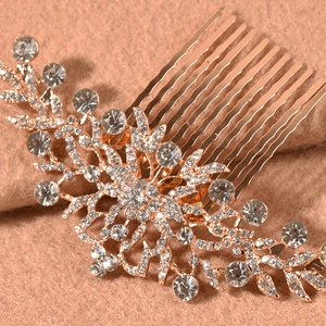 Detail of rose gold bridal hair comb with sparkling rhinestones in a floral leaf design