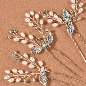 Detail of silver leaf bridal hair pin set with pearls and rhinestones on wood
