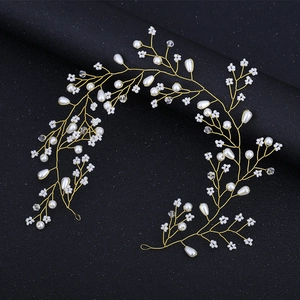 Détail d'une vigne de cheveux de mariée en fil doré avec perles blanches et cristaux