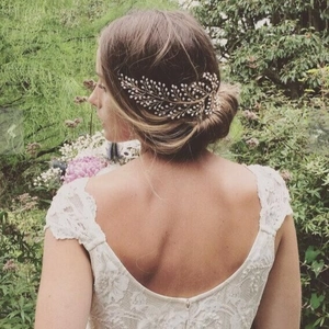 Elegant bridal hair comb with gold wire leaves and white pearls in a romantic updo