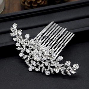 Close-up of silver bridal hair comb with floral rhinestone patterns on black background
