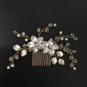 Close-up of golden wire bridal hair comb with white pearls and sparkling floral crystals